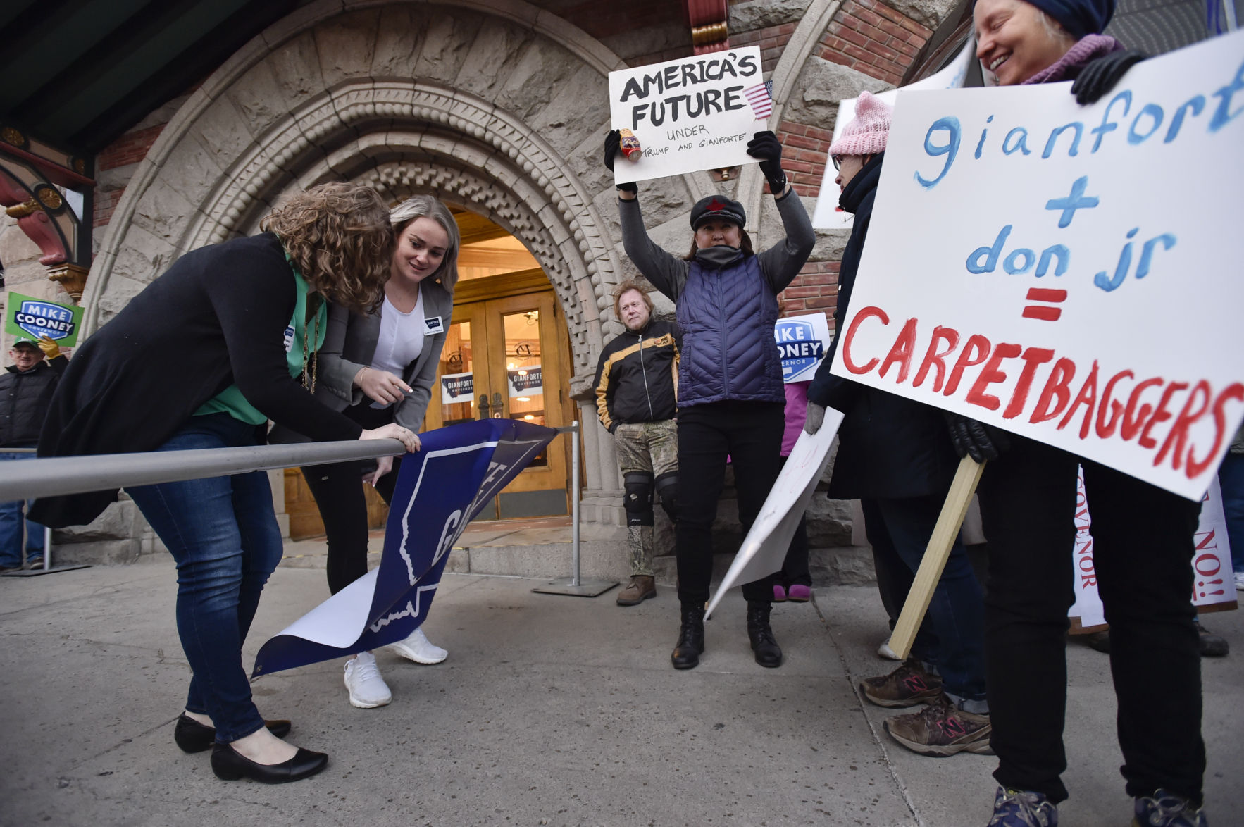 Republican party staffers hang a Greg Gianforte campaign poster